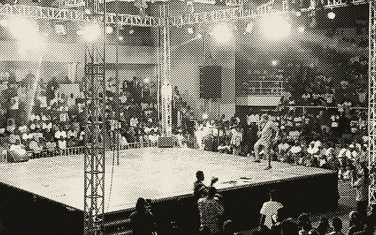 Ring surélevé sous les projecteurs lors d'une soirée de boxe, devant le public